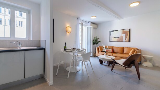 A modern kitchen with a dining area, a sofa, and a coffee table.