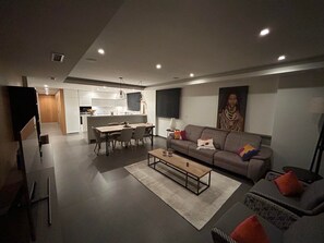 Un salon moderne avec un canapé, une table basse et un coin repas.