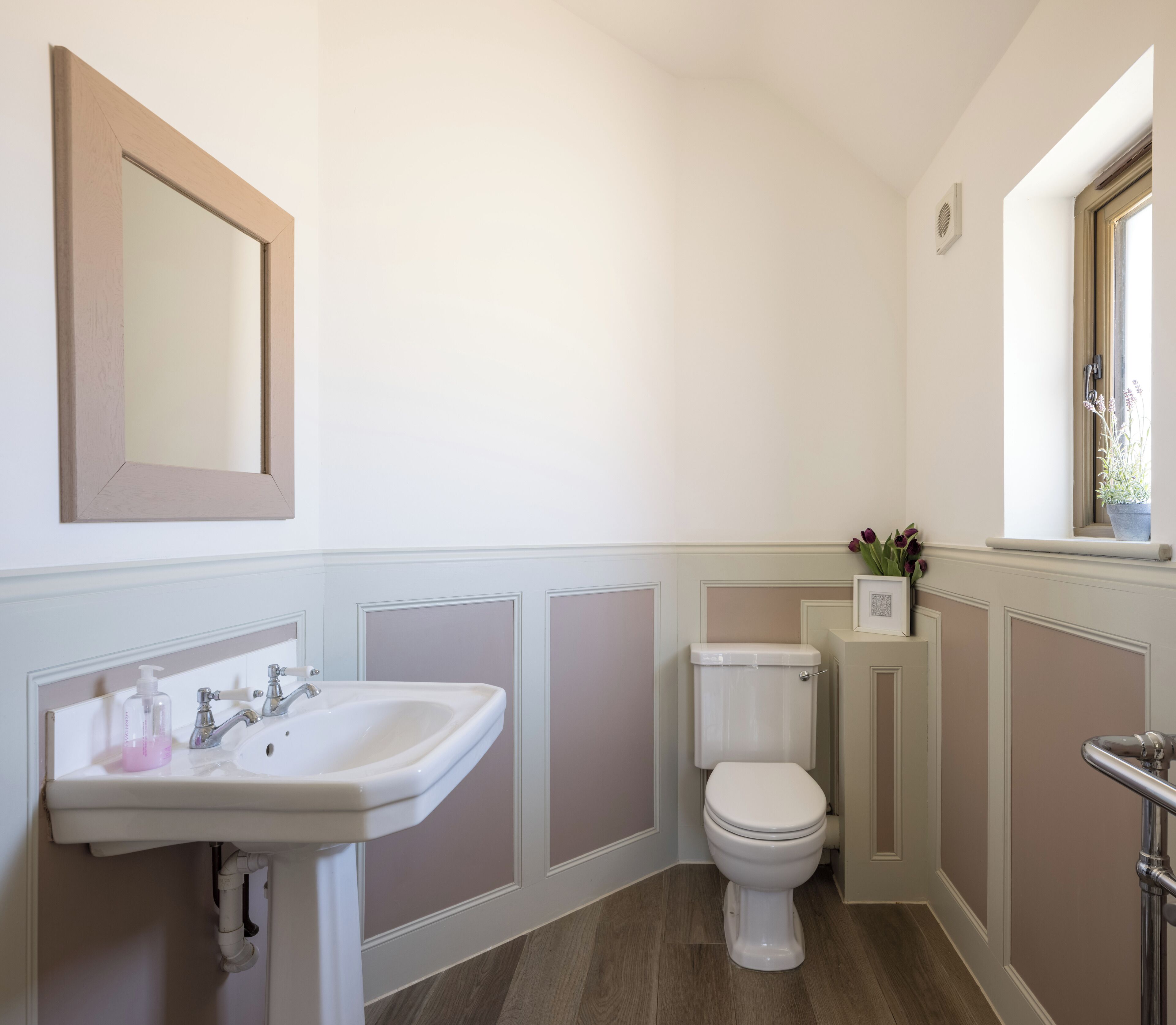 A bathroom with a white sink, a toilet, and a mirror.