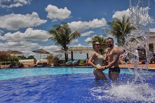 Una piscina techada, una piscina al aire libre, sombrillas