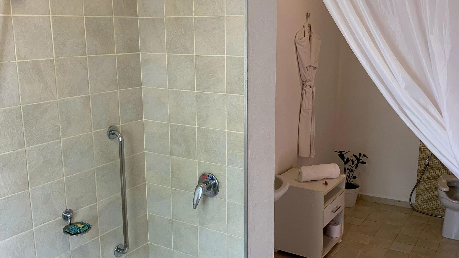 Une salle de bain avec une douche, des toilettes et un lavabo.