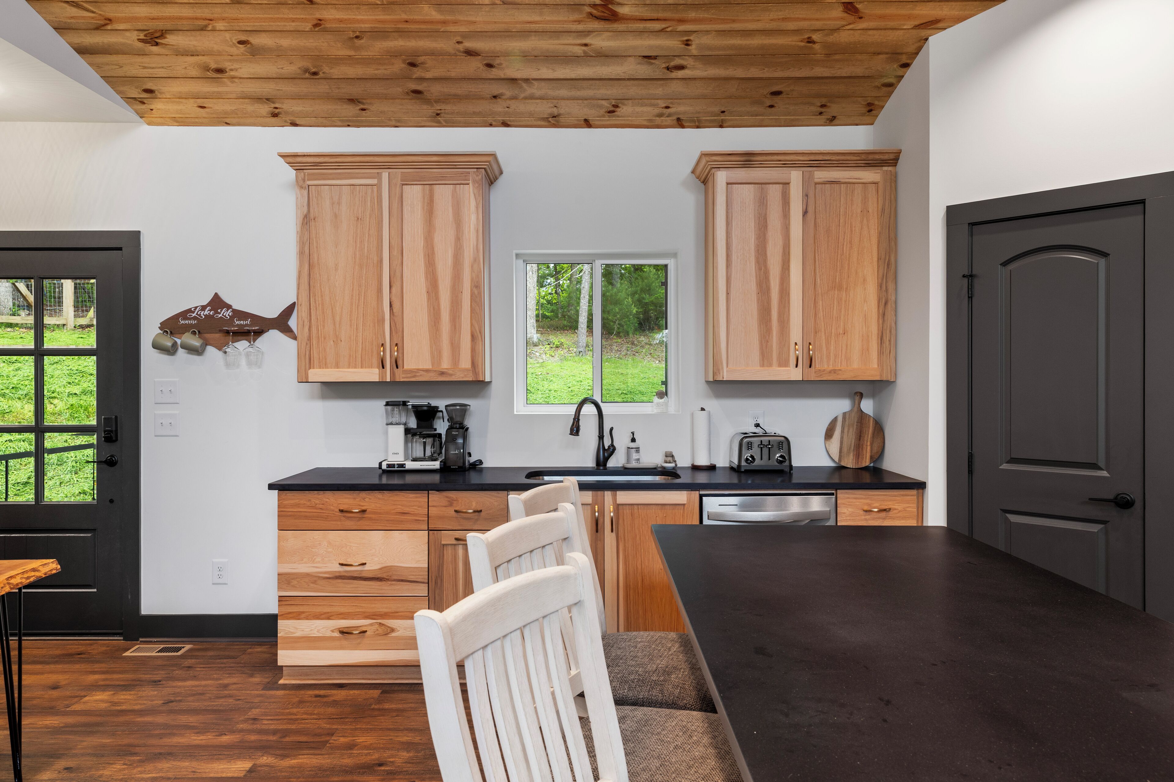 Una cocina moderna con armarios de madera, una encimera negra y vistas al exterior.