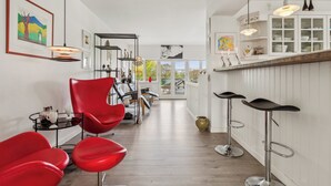 A modern interior with red chairs, a bar area, and artwork on the walls. - Sea and meadow views – space and calm (Nyborg)