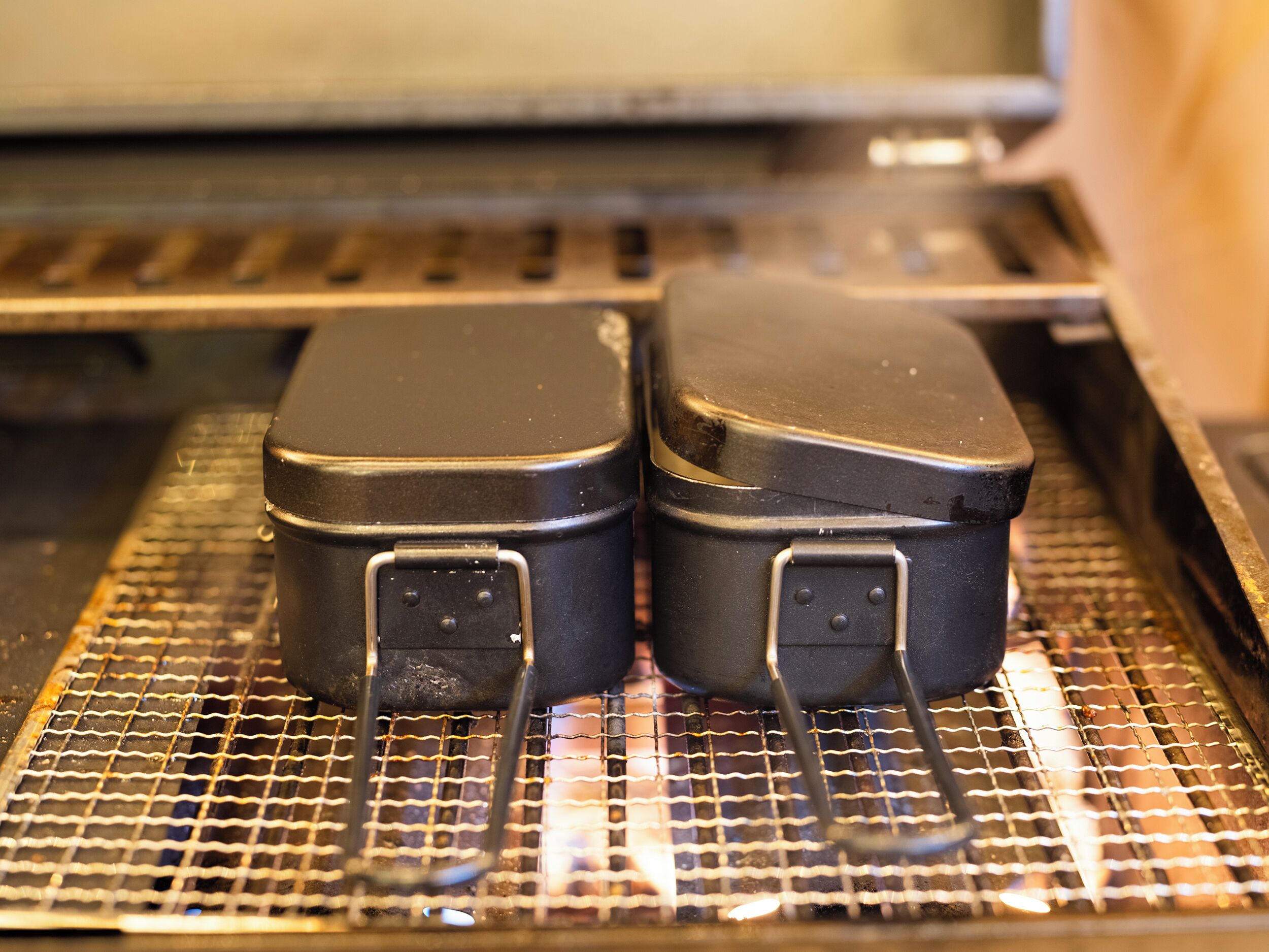 Two black suitcases on a conveyor belt.