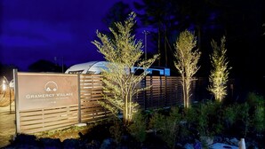 A sign for Gramercy Village with a spa and sauna, surrounded by trees and a fence. - Gramercy Village Yamanakako (Yamanakako)