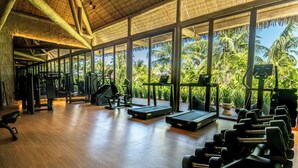 A gym with exercise equipment, large windows, and a wooden floor. - NANNAI Milagres (Passo de Camaragibe)