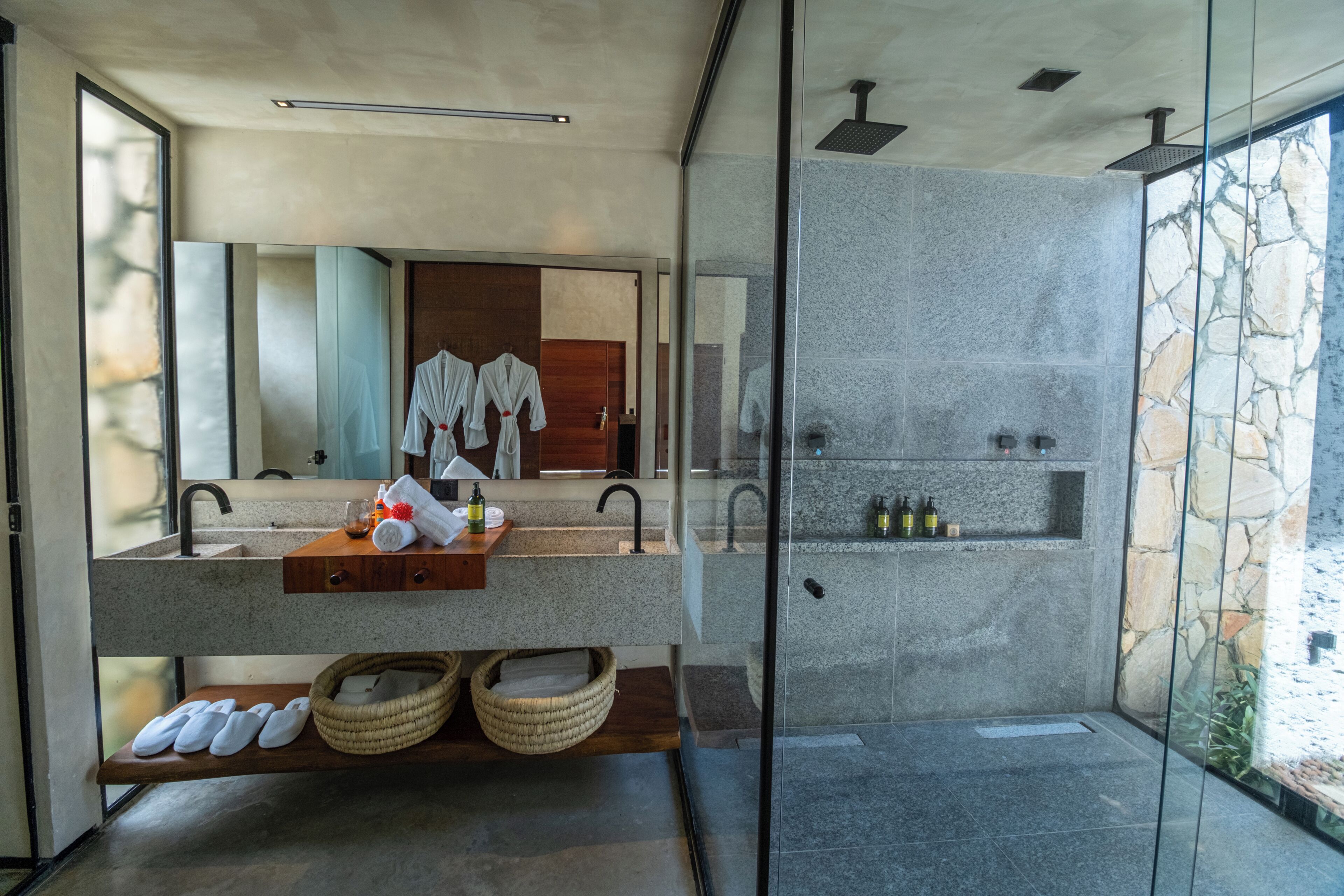 A modern bathroom with a glass shower enclosure, dual sinks, and a large mirror.
