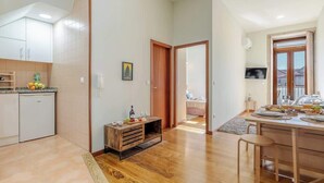 Una cocina amplia con armarios de madera, un comedor con mesa y sillas de madera, y vistas al exterior a través de una puerta.