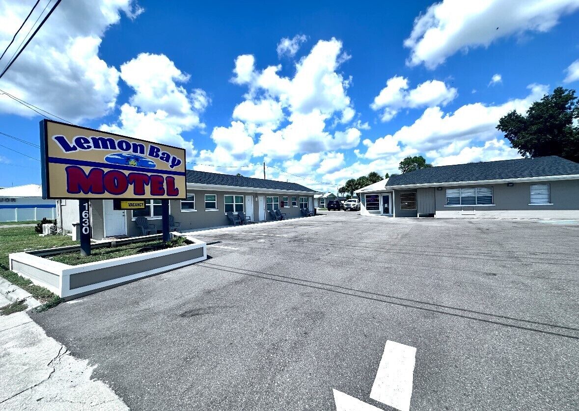 A Lemon Bay Motel with a clear sky and a parking lot.