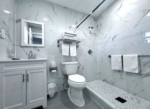 Habitación doble estándar | Baño | Regadera, toallas, jabón, shampoo 