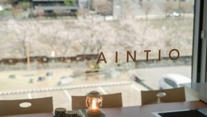 A window with the word "AINTIO" and a view of a snowy landscape outside. - Namyangju Aintio Pension (Namyangju)