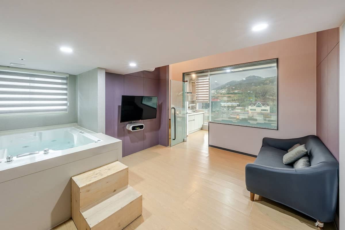 Un baño moderno con bañera, televisión y cabina de ducha de vidrio.