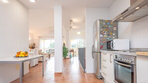 Una cocina moderna con armarios blancos, un refrigerador de acero inoxidable y un horno empotrado.