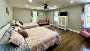 A hotel room with two beds, a sofa, a TV, and a ceiling fan. - Historic Holiday Family Gatherings, Hot tub/ Pool,  45 min to Louisville. (Brandenburg)