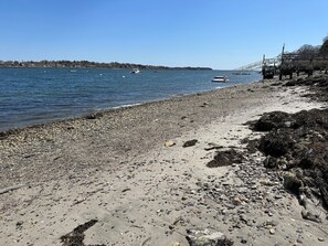 Enjoy a serene beach experience with a boat on the water and a pier for fishing or scenic views.