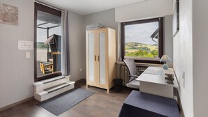 A room with a view, a wardrobe, a desk, and a chair. - Holiday Apartment 'Zum Hasen' with Mountain View, Private Terrace and Wi-Fi (Meschede)