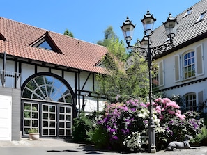 A traditional building with a tiled roof, a large arched window, and a street lamp.