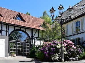 A traditional building with a tiled roof, a large arched window, and a street lamp.