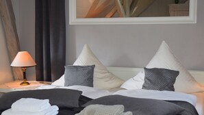 A hotel room with a bed, pillows, a lamp, and a mirror. - Country House Bornemann Apartment 6 (Diemelsee)