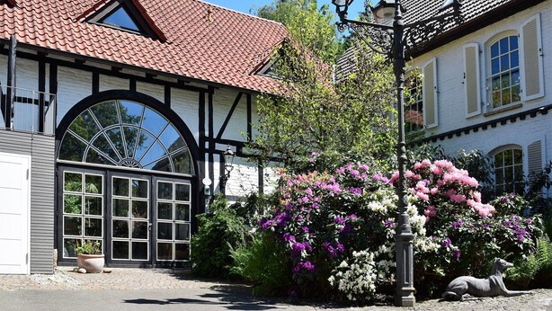 A traditional building with a tiled roof, a large arched window, and a street lamp. - Landhaus Bornemann Holiday Apartment 7 (Diemelsee)