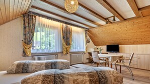 A cozy room with a bed, a desk, and a TV. - Gästehaus Gerda: Double Room 4 with Mountain View and Wi-Fi (Bad Peterstal-Griesbach)