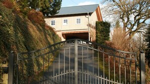 Un cancello che dà accesso a una proprietà, con un viale che conduce a un edificio.