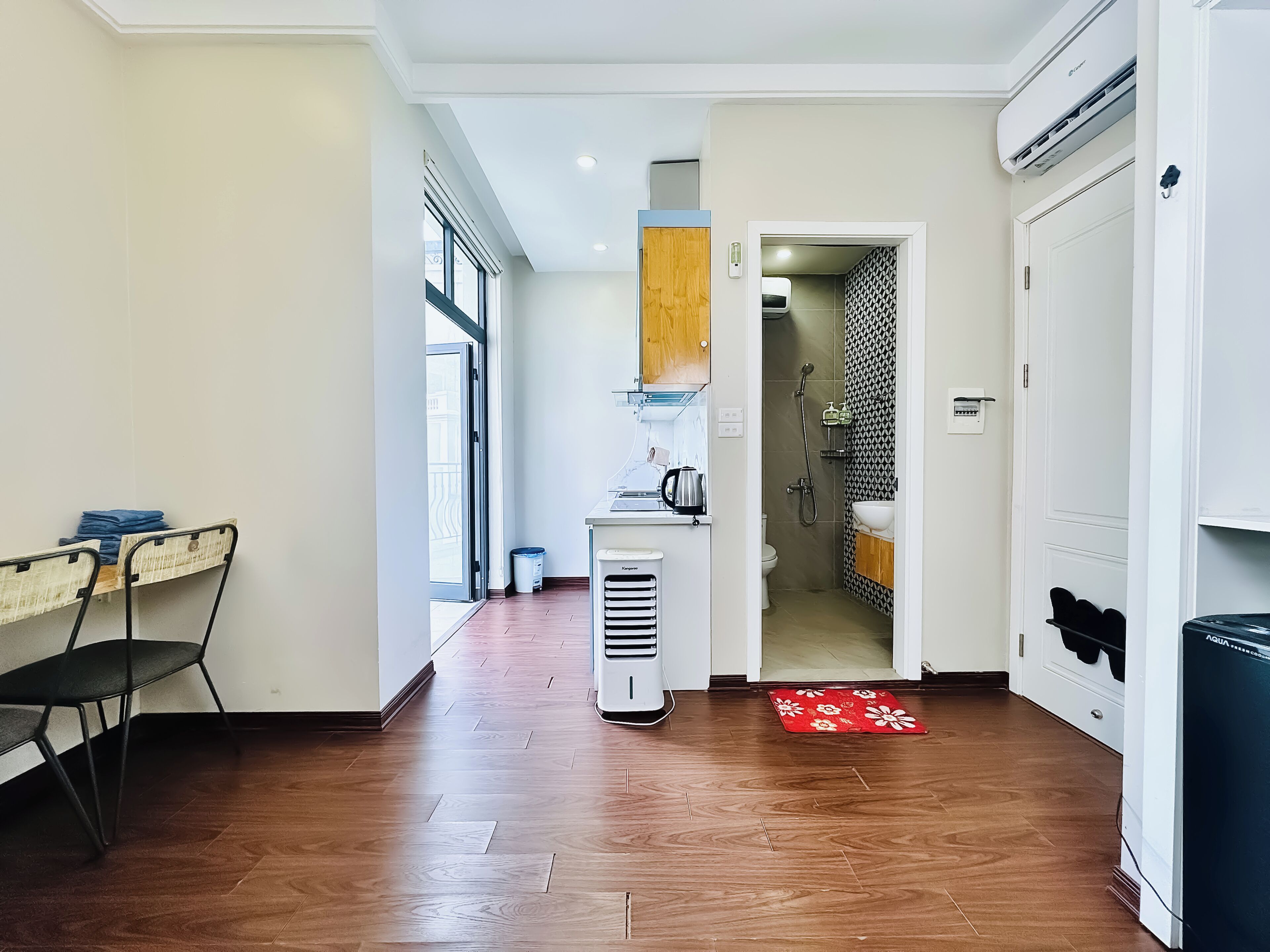 A modern kitchen with a built-in oven, a coffee machine, and a small sink.