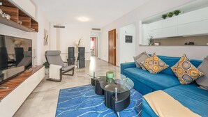 Una sala de estar moderna con un sofá, una mesa de centro y una televisión.