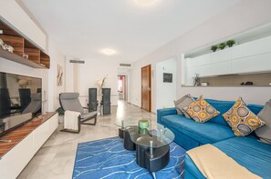 Una sala de estar moderna con un sofá, una mesa de centro y una televisión.