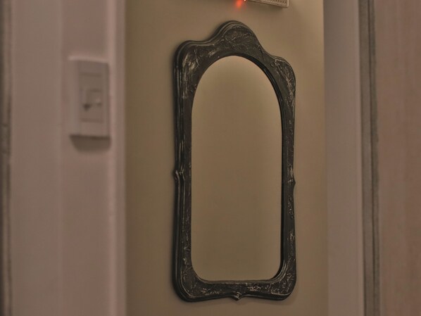 A mirror with an ornate frame mounted on a wall.