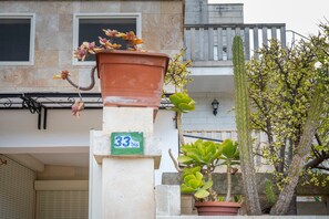A building with a number '33' sign, a potted plant, and a cactus.