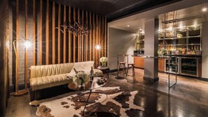 Un salón moderno con un sofá de cuero, un tapete de piel de vaca y una pared con listones de madera.