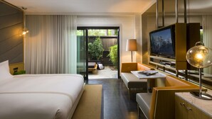 A hotel room with a bed, a desk, a television, and a view of the outdoors. - King Room at a 4⭐️ Hotel (Los Angeles)