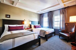 A hotel room with two beds, a chair, a nightstand, a lamp, and a window with curtains. - 1-Bedroom Suite at a 4⭐️ Hotel (Los Angeles)