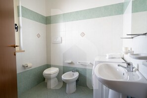Een douche, een haardroger, een bidet, handdoeken