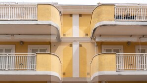 A multi-story building with yellow walls and white balconies. - Homiday - Via Gramsci Int.8, 3-room apartment on the 2nd Floor (Pineto)