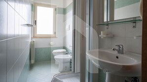 A modern bathroom with a glass shower enclosure, a white sink, and two toilets. - Homiday - Via Gramsci Int.8, 3-room apartment on the 2nd Floor (Pineto)