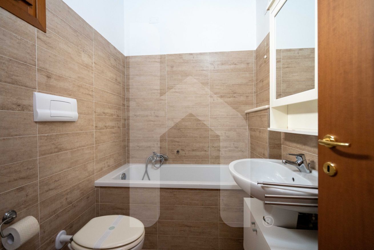 Un bagno con il water, il lavandino e una vasca da bagno.