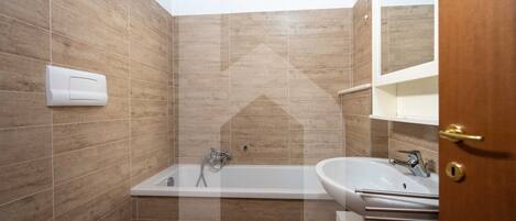 Un bagno con il water, il lavandino e una vasca da bagno.