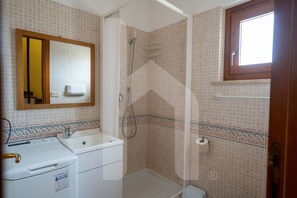 Une salle de bain équipée d’une douche, d’un lavabo, de toilettes et d’un miroir.
