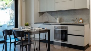 Una cocina moderna con comedor, que incluye un horno empotrado, un lavamanos y una encimera con un adorno.