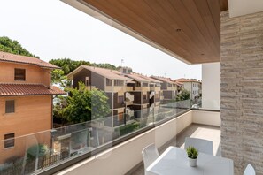 A balcony with a glass railing overlooking a row of houses. - Homiday - Pinetina Residence Int. 05 (Pineto)