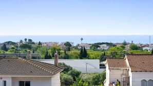 A residential area with terracotta-tiled roofs, a clear sky, and a view of the sea. - Apartment 'Montsant' with Sea Views, Private Terrace and Air Conditioning (Creixell)