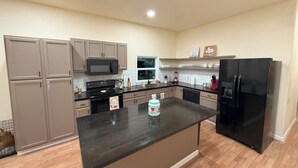 Una cocina moderna con una isla central, electrodomésticos integrados y una paleta de colores neutros.