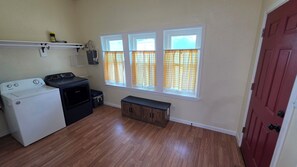 A laundry room with a washer, dryer, and a bench. - 3-bedroom house in charming Waco with WiFi, AC. Start your getaway (Waco)
