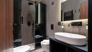 Une salle de bain moderne avec une douche à parois de verre, un lavabo blanc et des toilettes.