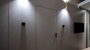 A hallway with two doors, a wall-mounted intercom, and a flat-screen TV. - Apartment In A Hotel '4 Season Cognetti Room 3' with Wi-Fi and Air Conditioning (Bari)