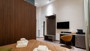 A hotel room with a bed, a desk, a chair, a flat-screen TV, and a coffee machine. - Apartment In A Hotel '4 Season Cognetti Room 3' with Wi-Fi and Air Conditioning (Bari)