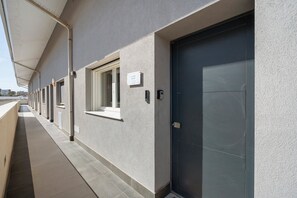 Esterno di un edificio con diverse porte, una tettoia e un cartello che indica 'LUXURY ROOM'.