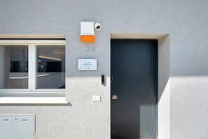 A building facade with a numbered door, a mailbox, and a window. - 'Luxury Terrazza' Apartment with Sea View, Wi-Fi, and Air Conditioning (Bari)